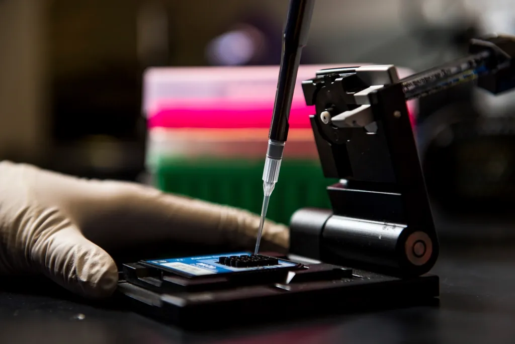 Pipette dispensing a sample into a laboratory plate